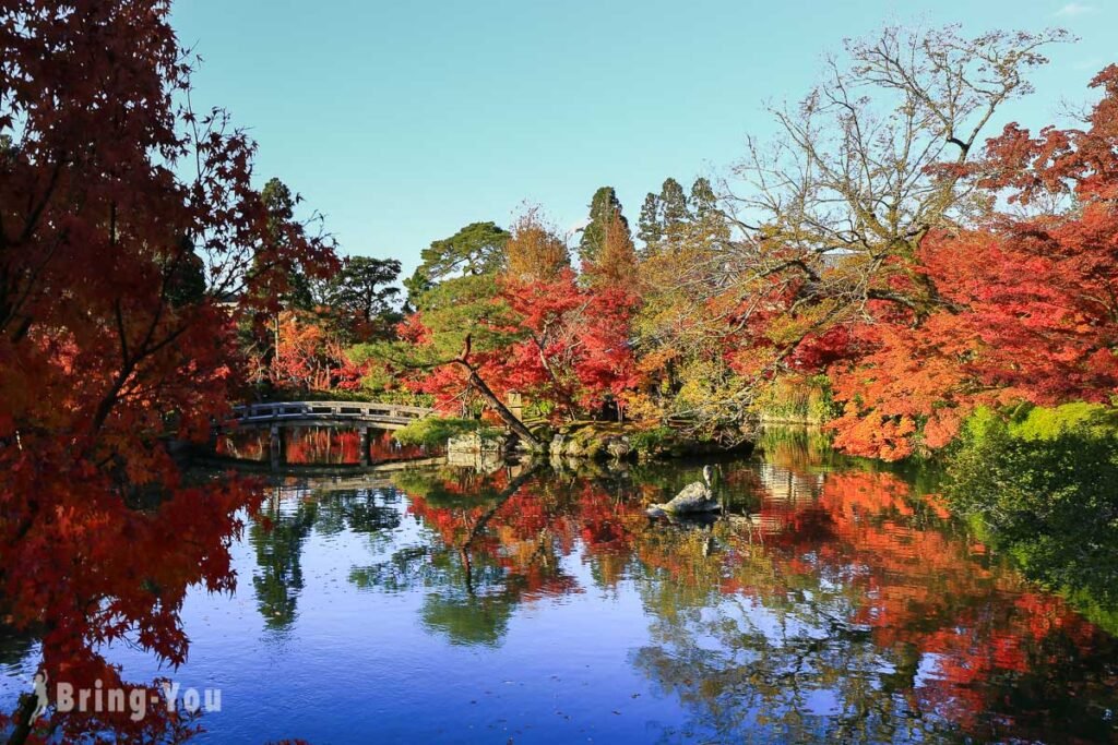 A historic Japanese temple framed by red and orange maple leaves